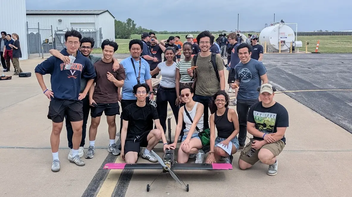 the team gathered around the aircraft at competition